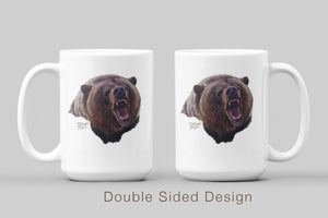 White ceramic coffee mug featuring a painting of a grizzly bear in an aggressive posture by artist Des McCaffrey, displaying both sides.