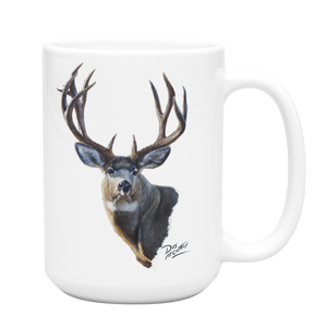 White ceramic coffee mug featuring a painting of a mule deer buck with large antlers, artwork by Canadian wildlife artist Des McCaffrey.