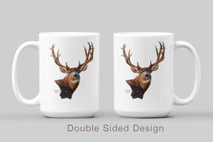 White ceramic coffee mug featuring a painting of a mule deer buck with large antlers, artwork by Canadian wildlife artist Des McCaffrey, displaying both sides of mug. 